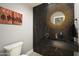 Chic powder room with black marble and a round mirror at 9919 N 47Th Pl, Phoenix, AZ 85028