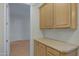 Laundry room with wood cabinets, countertops, and a door leading to another room at 13602 N 12Th Pl, Phoenix, AZ 85022