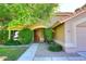 House entrance with a brown door and walkway, surrounded by bushes at 14267 S 43Rd Pl, Phoenix, AZ 85044