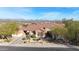 An aerial view of a two-story home with a tiled roof, desert landscaping, a paved driveway, and mountain views in the background at 3512 W Hidden Mountain Ct, Phoenix, AZ 85086