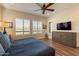 Spacious main bedroom with wood-look tile, ceiling fan, and plantation shutters at 36011 N Stoneware Dr, Queen Creek, AZ 85140