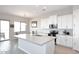 Bright, spacious kitchen with white shaker cabinets, stainless steel appliances, and a large island with quartz countertop at 36023 N 140Th St, Scottsdale, AZ 85262