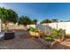 Spacious backyard with garden beds, orange tree, and AC unit at 5502 E Baywood Ave, Mesa, AZ 85206