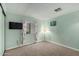 Cozy bedroom with light green walls, carpeted flooring, and a wall-mounted TV at 5502 E Baywood Ave, Mesa, AZ 85206