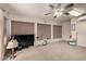 Bonus room furnished with an exercise bike, a large TV, and vertical blinds on the windows at 5502 E Baywood Ave, Mesa, AZ 85206