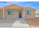 Close-up view of a home's covered entryway with a dark front door at 735 E Hanna Rd, Eloy, AZ 85131