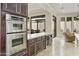 Kitchen with double oven, microwave, wine fridge, and dark wood cabinets at 8146 E Wingspan Way, Scottsdale, AZ 85255