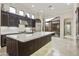 Modern kitchen with dark wood cabinets, stainless steel appliances, and large island at 8146 E Wingspan Way, Scottsdale, AZ 85255