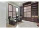 Home office with built-in bookshelves, comfortable seating, and plantation shutters at 8146 E Wingspan Way, Scottsdale, AZ 85255