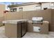 Outdoor kitchen with built-in grill, refrigerator, and tiled countertop at 8146 E Wingspan Way, Scottsdale, AZ 85255