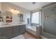 Modern bathroom with double vanity, soaking tub, glass shower, and tiled walls at 8214 S 15Th St, Phoenix, AZ 85042