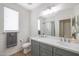 Modern bathroom with dual vanity, large mirror, and gray cabinets at 8214 S 15Th St, Phoenix, AZ 85042