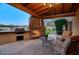 Covered patio with outdoor fireplace, grill, and seating area at 8304 E Gail Rd, Scottsdale, AZ 85260