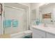 Clean bathroom with sliding glass shower doors, white vanity, and frosted glass window at 14015 N 111Th Ave, Sun City, AZ 85351