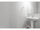 Small half bathroom with pedestal sink and mirror at 22459 E Marsh Rd, Queen Creek, AZ 85142