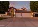 Inviting two-story home with a three-car garage and festive lighting at dusk at 2280 E Stephens Pl, Chandler, AZ 85225