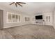 Living room with carpet, fireplace, large windows, and a ceiling fan at 2280 E Stephens Pl, Chandler, AZ 85225