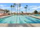 Sparkling community pool with palm trees and reflections of the sun at 24407 S Starcrest Dr, Sun Lakes, AZ 85248