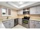Kitchen boasts stainless steel appliances, white cabinets, and tile flooring at 4303 E Cactus Rd # 146B, Phoenix, AZ 85032