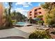 Community pool with a rock waterfall feature, lounge chairs, and umbrellas at 4303 E Cactus Rd # 146B, Phoenix, AZ 85032