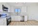 Modern kitchen with white cabinetry, stainless steel appliances, and wood-look flooring at 452 S Daley --, Mesa, AZ 85204