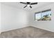 Cozy bedroom with plush carpeting, ceiling fan, and large window at 607 E Manhatton Dr, Tempe, AZ 85282