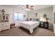 Cozy bedroom with a ceiling fan, carpeted floors, and large window at 6180 N 88Th Ln, Glendale, AZ 85305