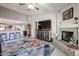 Living room featuring a fireplace, ceiling fan, and view of the adjacent kitchen at 6180 N 88Th Ln, Glendale, AZ 85305