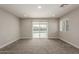 Carpeted living room with sliding glass doors offering access to the backyard at 9049 E Vine Ave, Mesa, AZ 85208