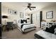 Modern bedroom with black and white decor, ceiling fan, and plush carpeting at 9424 E Hidden Spur Trl, Scottsdale, AZ 85255