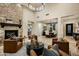 Open-concept living room with a stone fireplace, leather seating, and views of the dining area at 9424 E Hidden Spur Trl, Scottsdale, AZ 85255