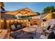 Cozy outdoor living space with a fireplace, comfortable seating, and string lights at 9424 E Hidden Spur Trl, Scottsdale, AZ 85255