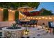 Charming patio area with a dining table, string lights, and lush landscaping at 9424 E Hidden Spur Trl, Scottsdale, AZ 85255