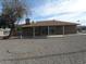 Gravel backyard with a covered patio and a large tree at 12218 N Mission Dr, Sun City, AZ 85351