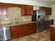 Kitchen features wood cabinets, tile counters, and stainless steel appliances at 12218 N Mission Dr, Sun City, AZ 85351