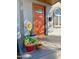 Inviting front porch with a vibrant orange door and potted plants at 1410 E Earll Dr, Phoenix, AZ 85014