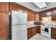 White appliances and wood cabinets in this galley-style kitchen at 14300 W Bell Rd # 501, Surprise, AZ 85374