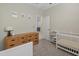 Bedroom with a crib, dresser, and view into dining area at 17352 W Country Club Ter, Surprise, AZ 85387