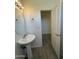 Half bathroom with a pedestal sink, toilet, and a view of an adjacent room at 1741 W Pollack St, Phoenix, AZ 85041