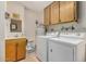 Bright laundry room, washer, dryer, cabinets, and countertop at 17624 N Lindgren Ave, Sun City, AZ 85373