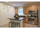 Updated kitchen with island, stainless steel appliances, and wood cabinets at 2135 N Heritage St, Buckeye, AZ 85396