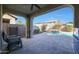 Inviting kidney-shaped pool with waterfall feature, spacious patio, and covered seating area at 2135 N Heritage St, Buckeye, AZ 85396