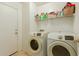 Laundry room with washer, dryer, and storage shelves at 24018 W Wayland Dr, Buckeye, AZ 85326