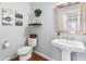 Clean powder room with pedestal sink, toilet, and decorative wall art at 3617 E Hazelwood St, Phoenix, AZ 85018