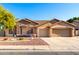 Tan house with stone accents, landscaped yard, and a two-car garage at 6898 W Saint John Rd, Glendale, AZ 85308