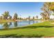 Serene lake view with fountain and lush green grass at 10214 E Michigan Ave, Sun Lakes, AZ 85248