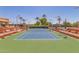 Clean tennis court with green surrounding at 10214 E Michigan Ave, Sun Lakes, AZ 85248