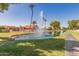 Peaceful canal-front view with fountain and palm trees at 10214 E Michigan Ave, Sun Lakes, AZ 85248