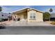 Single-wide yellow manufactured home with covered patio and desert landscaping at 17200 W Bell Rd # 91, Surprise, AZ 85374