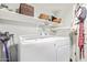 Bright laundry room with washer, dryer, and ample shelving at 20619 N 16Th Way, Phoenix, AZ 85024